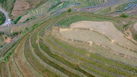 contoured landscape with small huts and intersected by a winding mountain road