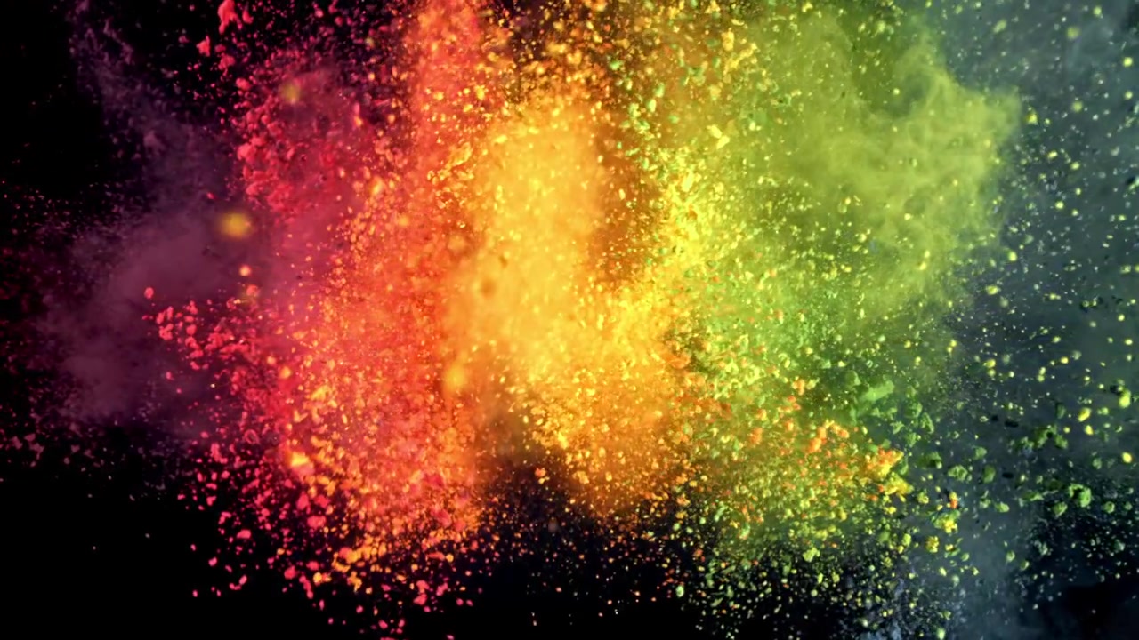 Polvo de colores explotando a cámara lenta sobre fondo negro