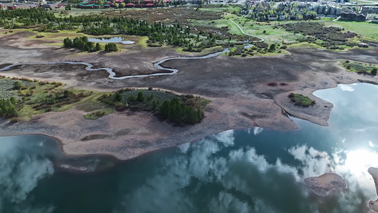 солнечный свет мерцает на спокойной спокойной воде водохранилища диллон, отражая облачное небо в фриско, колорадо.