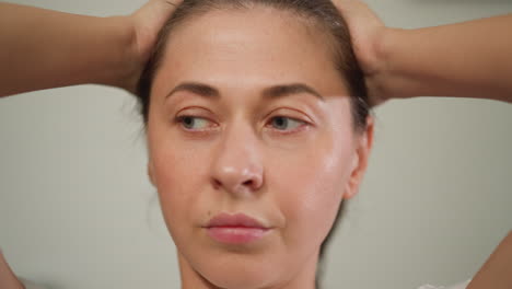 distraught woman grips head standing alone closeup. troubled lady contemplates problems in solitude at home grappling with weight of emotions