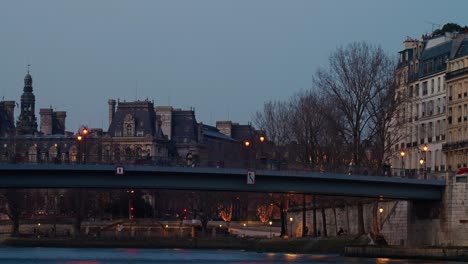 tourists crossing river seine on bridge while city lights light up paris time lapse 4k 30p