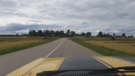 yellow with black stripes vintage car driving on a winding road