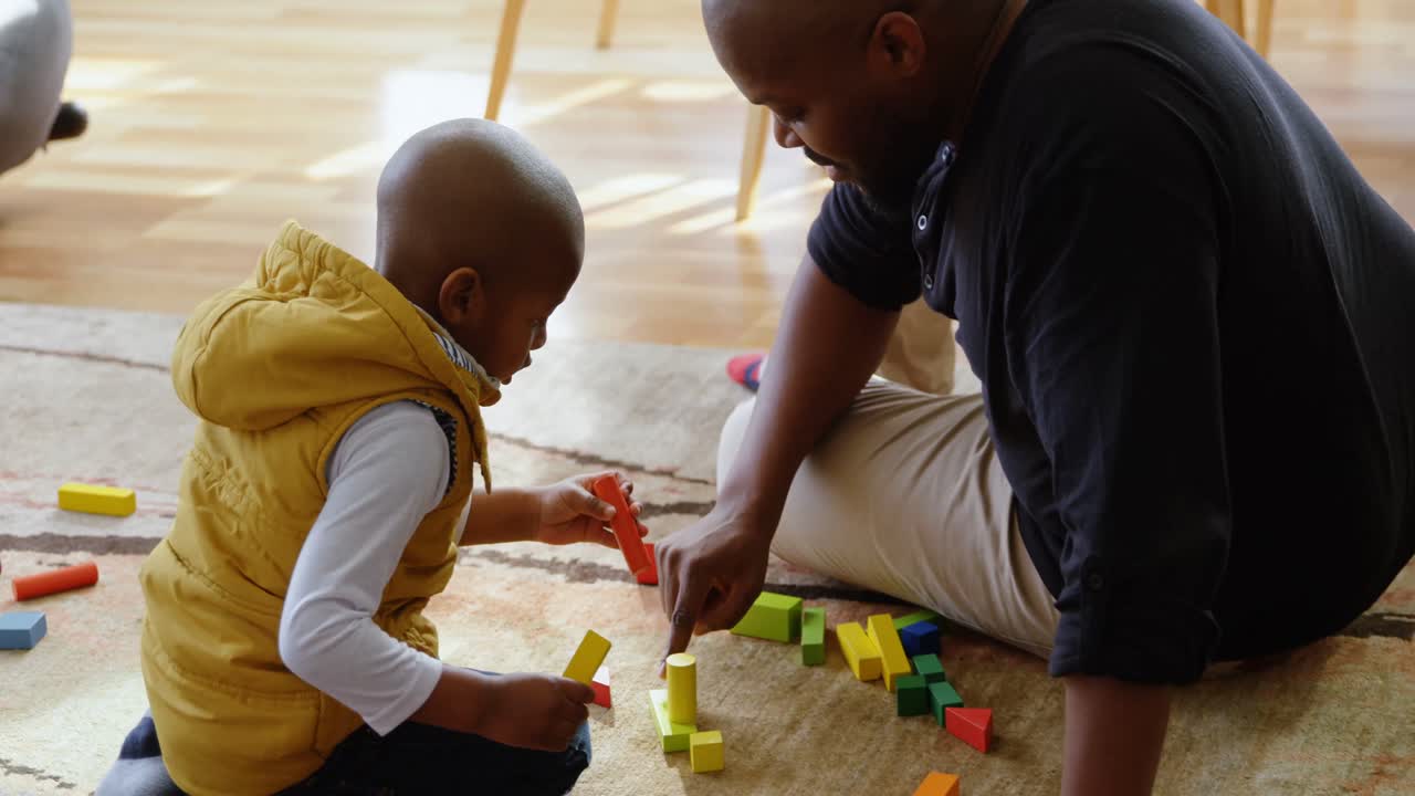 Father and son playing with building blocks in a comfortable home 4k