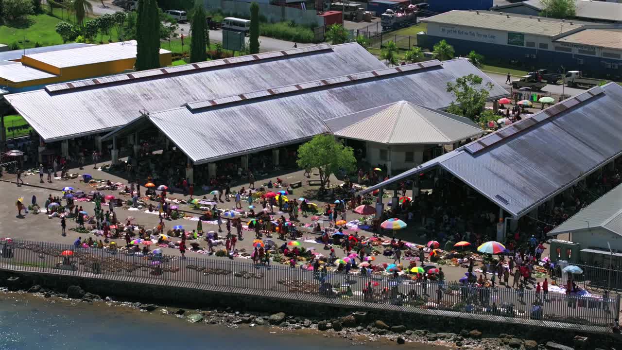 Sundaun fish Market Wewak Hill buildings traffic people Boram road Wewak Papua New Guinea aerial drone downtown coastal town Sundaun Market Dogreto Bay sunny blue sky morning circle left motion