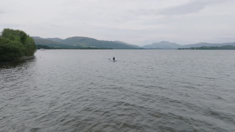 Langsame-Kamerafahrt-Einer-Jungen-Frau,-Die-Vom-Ufer-Des-Loch-Lomond-Paddelt