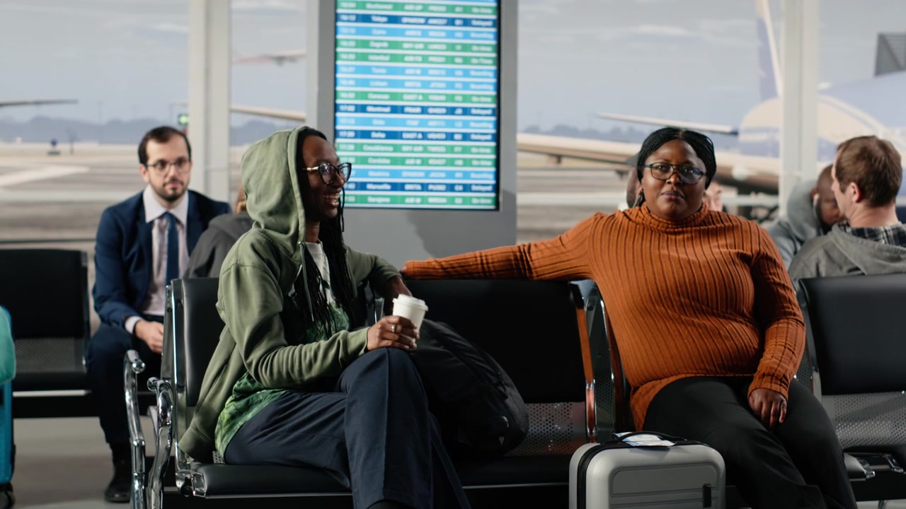 Women in airport terminal traveling together on vacation, chatting