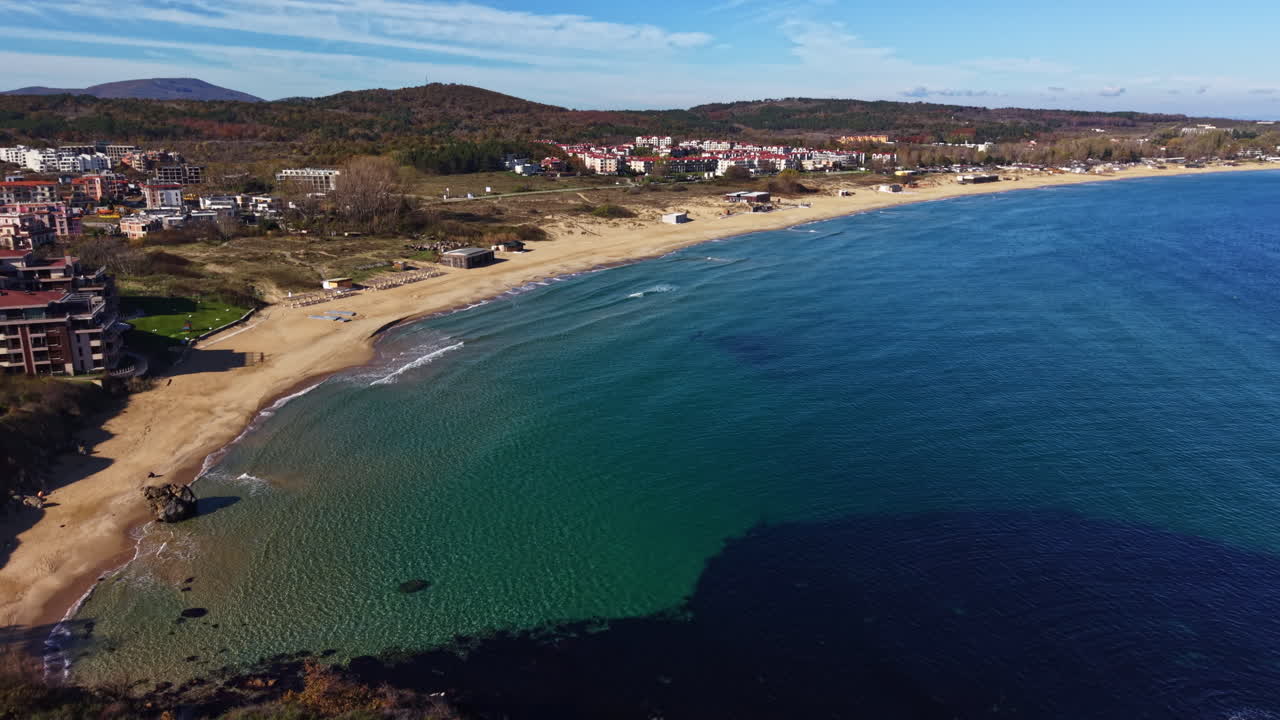 Scenic coastal view showcasing stunning blue waters and serene shoreline under a clear sky in an idyllic seaside town