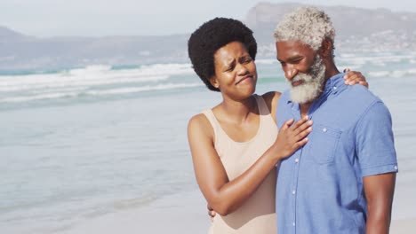 Glückliches-Afroamerikanisches-Paar,-Das-Am-Sonnigen-Strand-Spaziert-Und-Sich-Umarmt