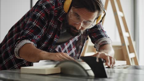 Handheld video of carpenter cutting wood on a circular saw
