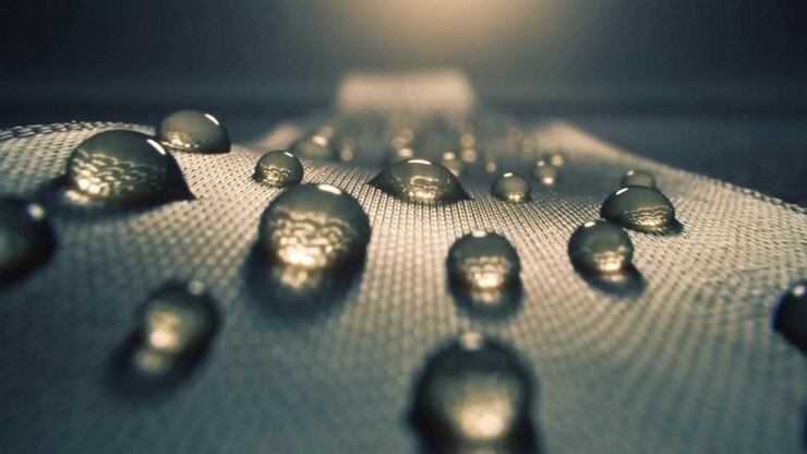 Moving camera starting near front droplet and tilting up along woven fabric, revealing highlights