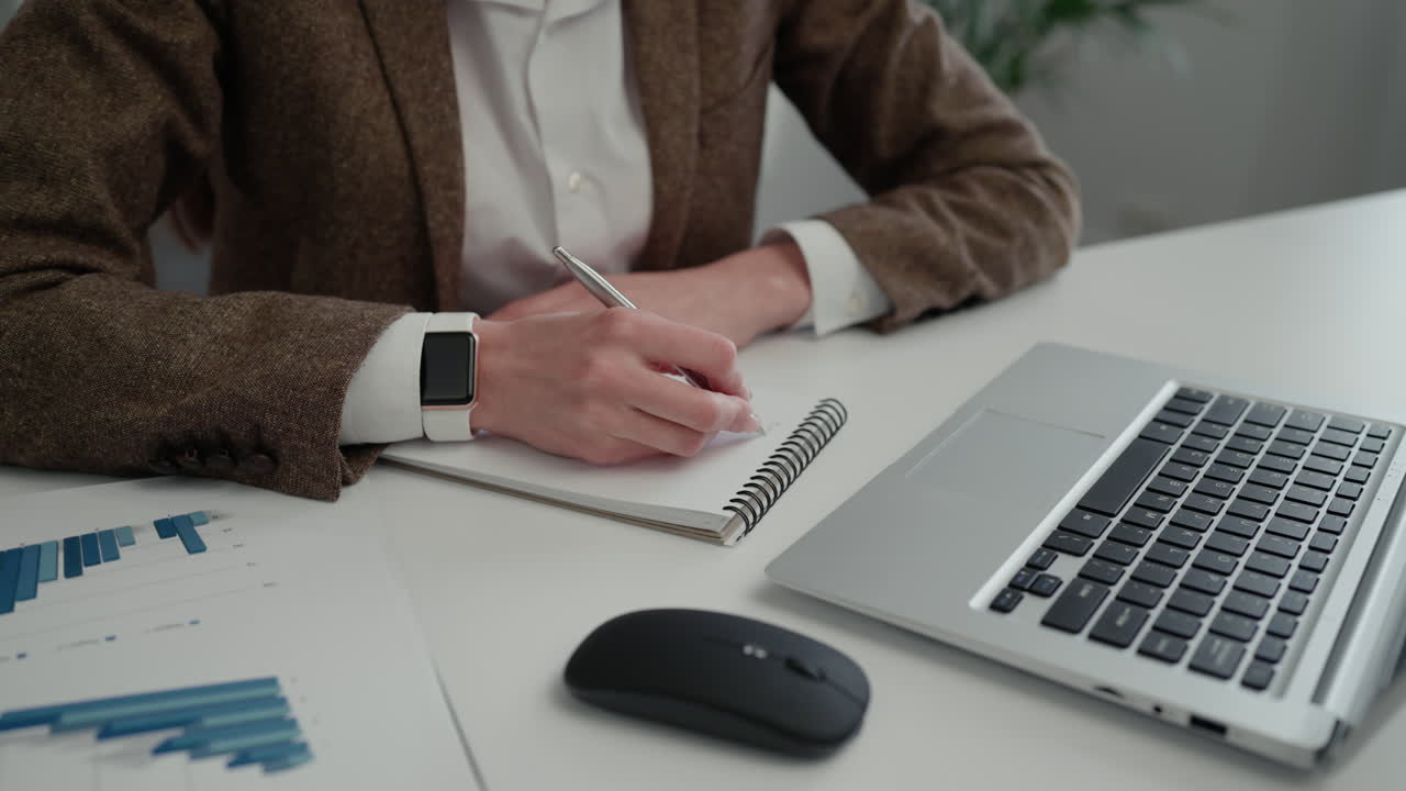 Working at a desk with a laptop and notebook