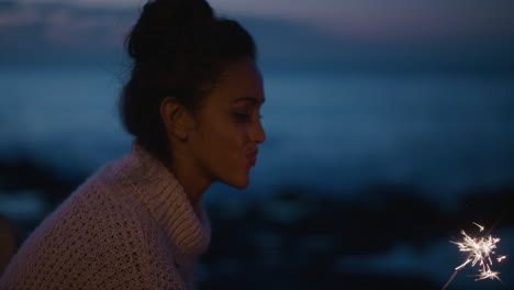 young hispanic woman waving sparkler celebrating new years eve enjoying calm seaside beach evening twilight celebration slow motion