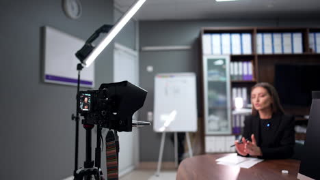 blog content creation. brunette female blogger speaks passionately to professional camera.