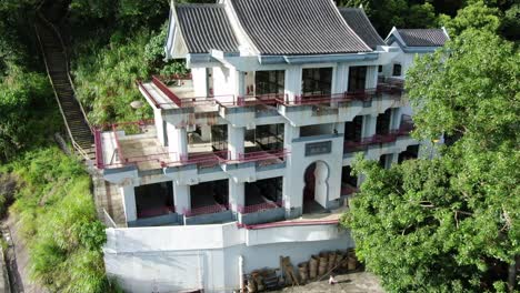 classic temple in hong kong, surrounded by lush green mountain terrain, aerial view