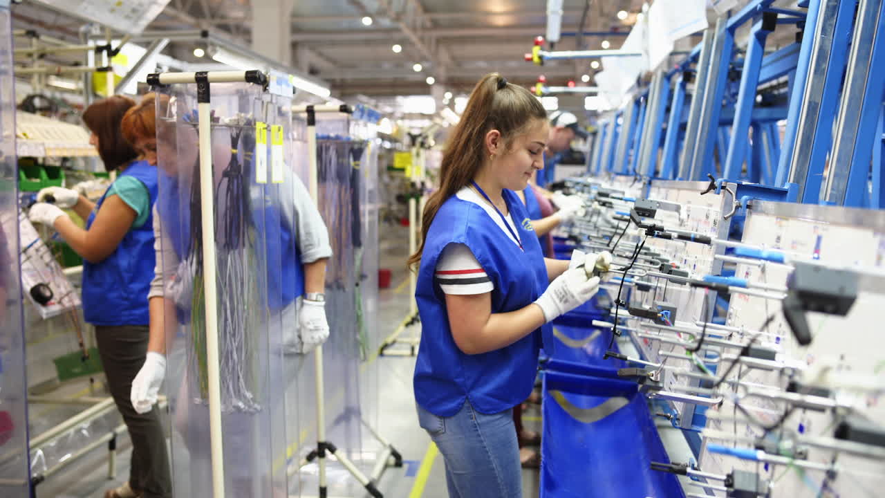 Portrait of factory worker. Female manuel workers team working on the production line in factory