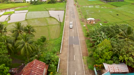 drone aerial of rice fields and road with cars in a small village in the philippines 4k