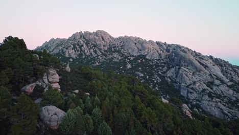 mountain peaks and forest against sundown sky