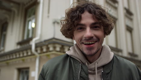 Happy-man-smiling-on-street.-Cheerful-guy-looking-camera-on-city-background.