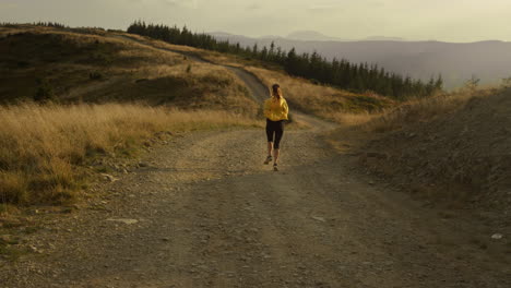 active woman running in mountains. female runner training on ground surface