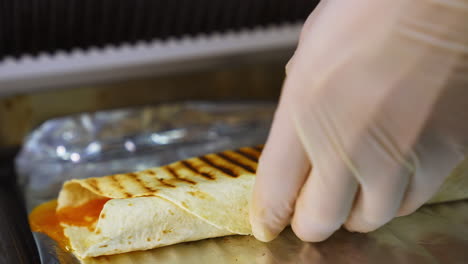 cheese shawarma with vegetables lies on a foil. grilled pita with ingredients. close up.