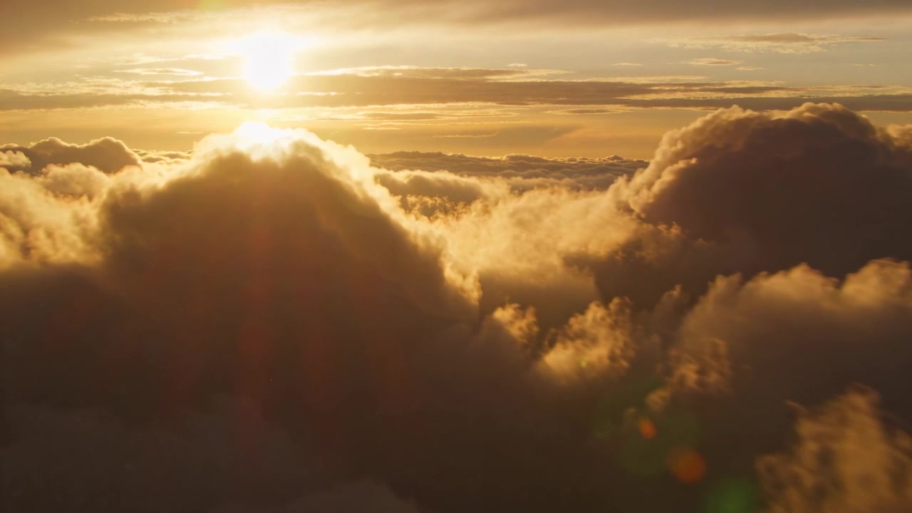 Drone in volo che rivela nuvole cumuliformi stratificate ad alta quota, catturando il lens flare del sole basso