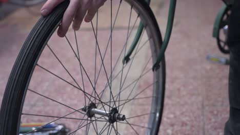 primer plano de una persona ajustando una rueda de bicicleta, centrándose en el cubo y los radios
