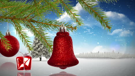 decoraciones de navidad colgando de una rama sobre la nieve cayendo sobre el árbol de navidad en el paisaje de invierno
