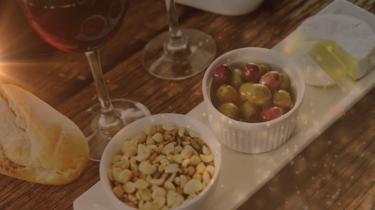 animación de luces sobre vino y bocadillos en una mesa de madera