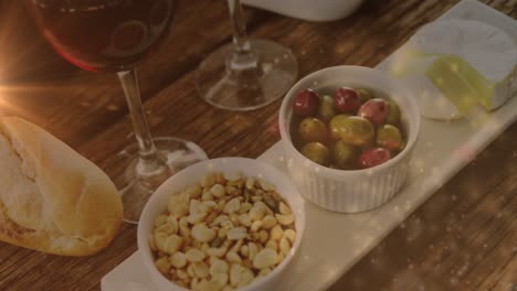 animation of lights over wine and snacks arrangement on wooden table