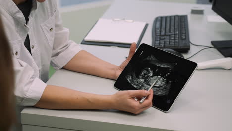 médico explicando la imagen en el dispositivo