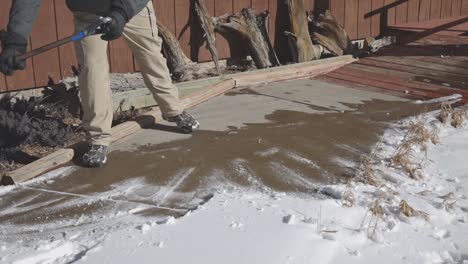 Man-shoveling-snow-off-of-a-sunny-walkway-in-a-mountain-suburb-in-the-mountains-of-Colorado