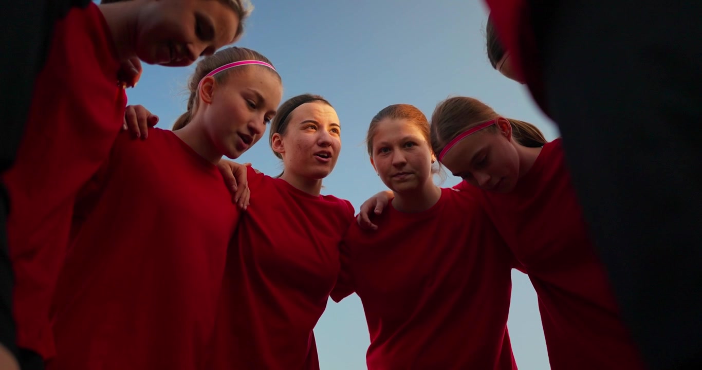 Young Female Soccer Players Huddle for Team Strategy