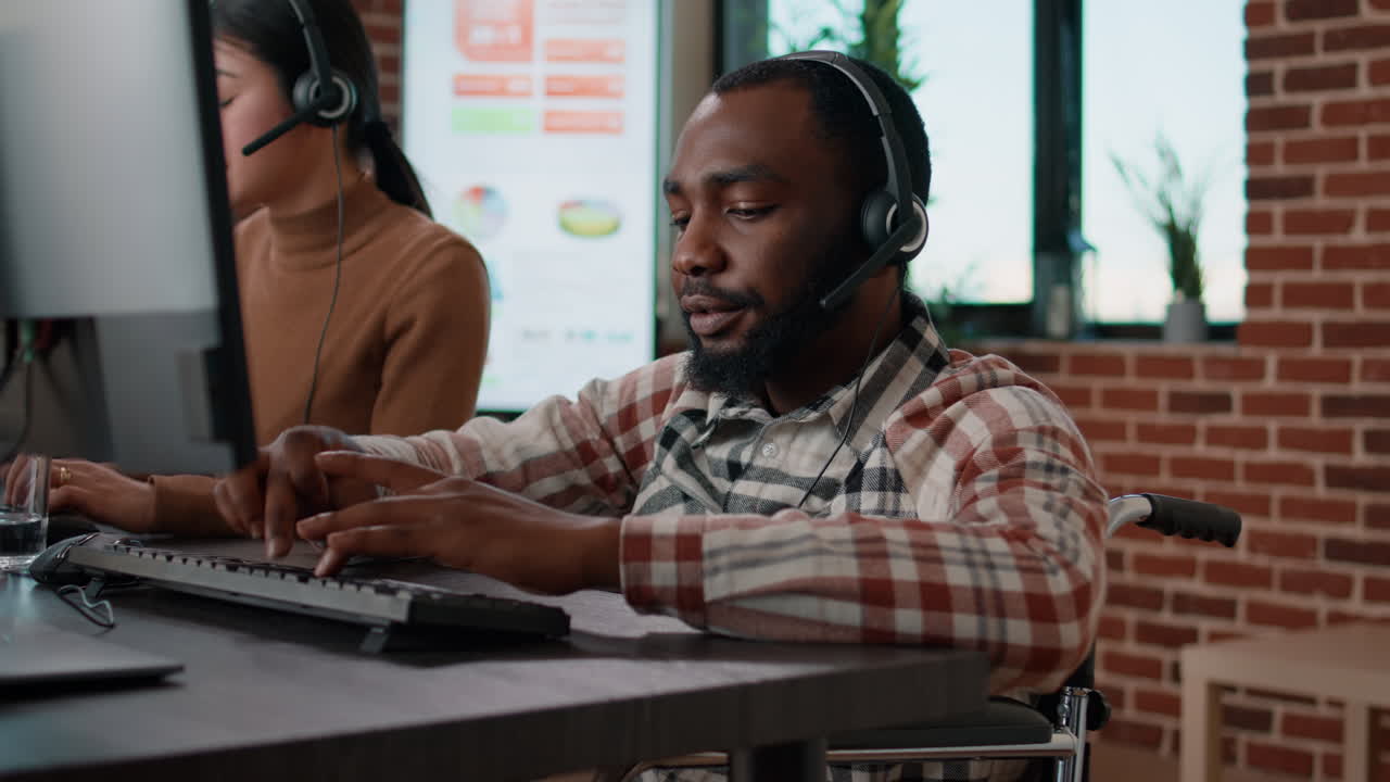 African american man in wheelchair answering helpline call