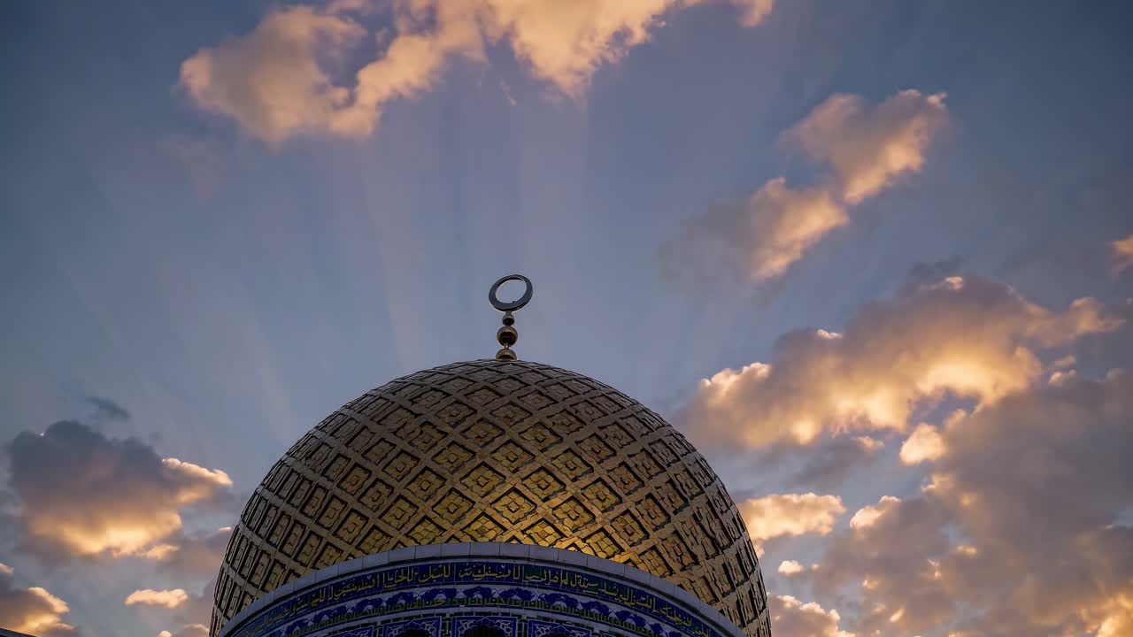 Kubah Masjid Emas dengan Simbol Bulan Sabit di Latar Belakang Awan Senja yang Bergerak