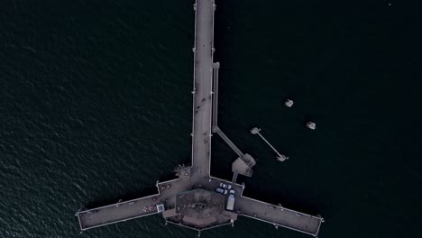 Aerial-bird's-eye-view-drone-shot,-drone-flying-along-with-Belmont-Veterans-Memorial-Pier-in-Long-Beach,-California