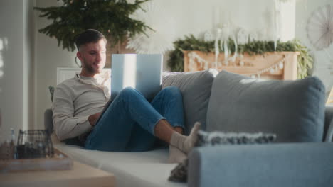 man working remotely from home on couch