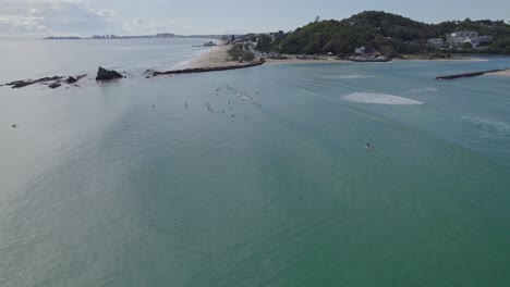 surfers at the currumbin beach on a sunny summer day in gold coast, queensland