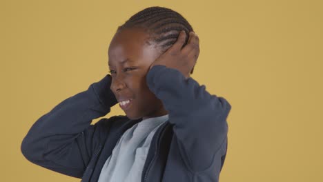 studio portrait of young boy on asd spectrum showing sensitivity to loud noises or sounds