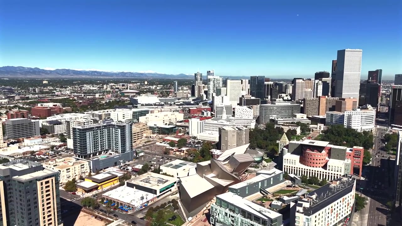 Un drone si allontana dal Denver Art Museum a mezzogiorno, rivelando lo skyline del centro e i grattacieli circostanti della città