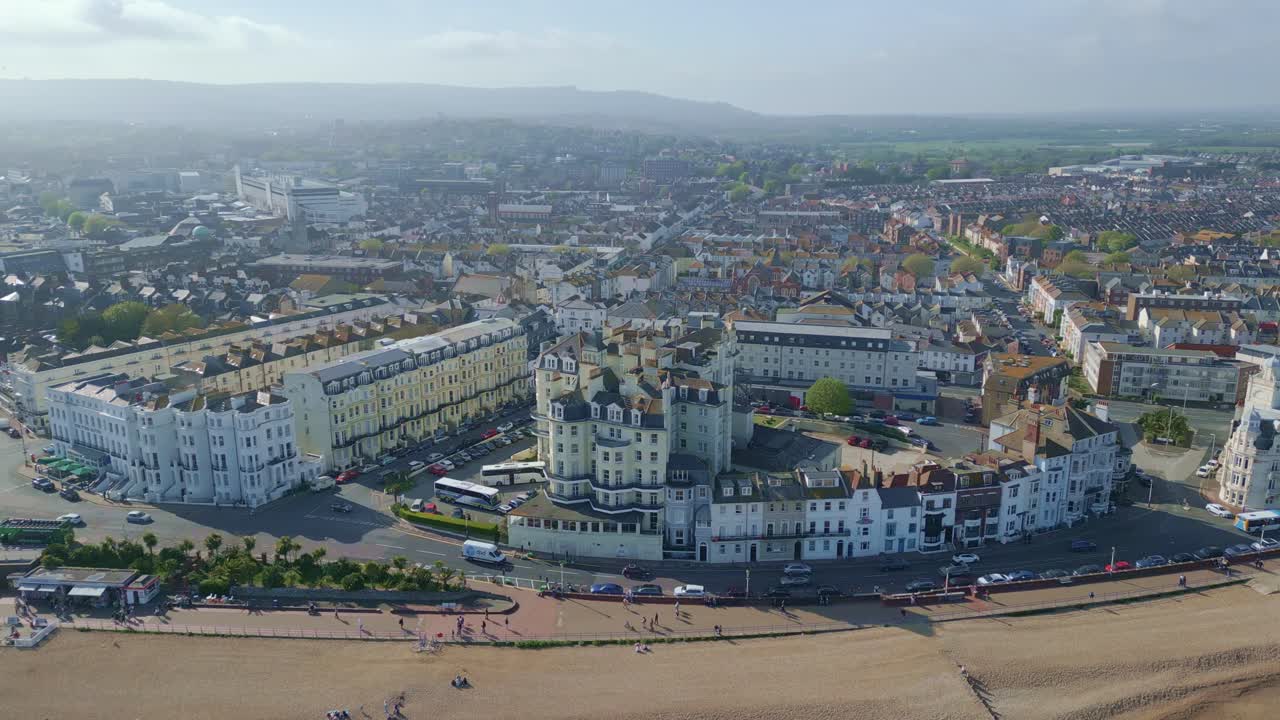 volando alrededor de eastbourne frente al mar edificios, carretera y coches