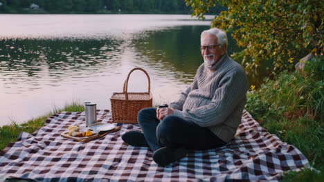 senior man enjoying a picnic by the lake