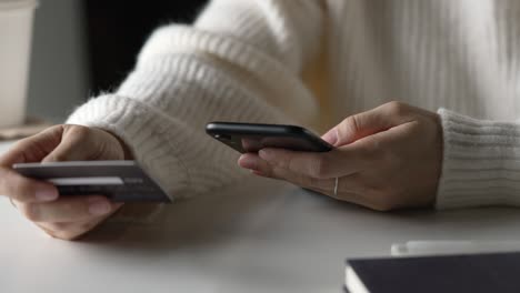 female hands holding credit card and using smartphone. online shopping