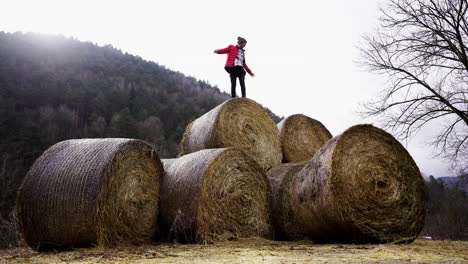 young athletic male hike hay bales in remote rural mountain farm, off grid successful happy life style in wilderness