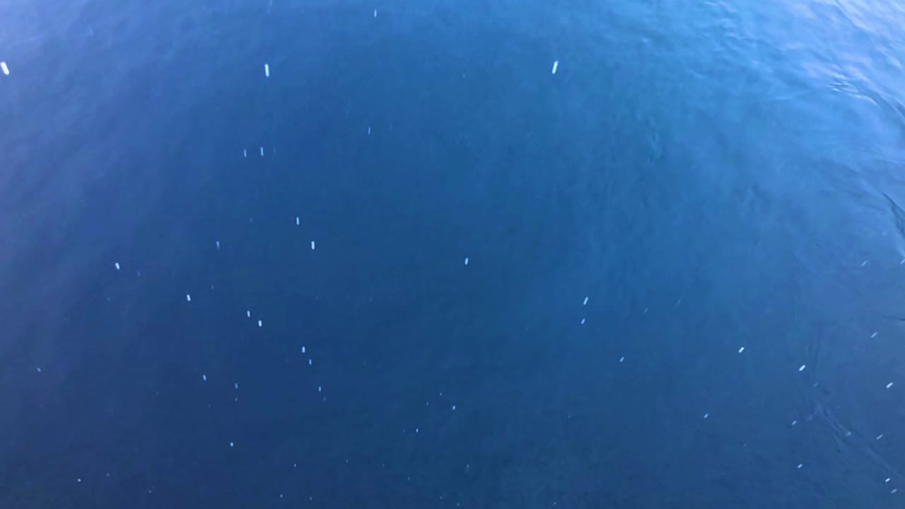 카리브해 섬 바로 앞바다에서 폭풍이 몰아치면서 비가 수정처럼 푸른 바닷물에 내립니다.