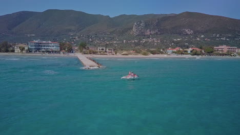 Aerial-orbits-small-boat-near-pier-in-beautiful-blue-Mediterranean-Sea