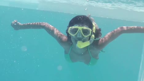 bonita morena buceando en la piscina con esnórquel