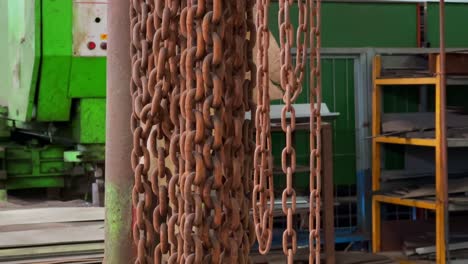 cadenas de hierro oxidado colgando con el fondo de un área de producción de la fábrica
