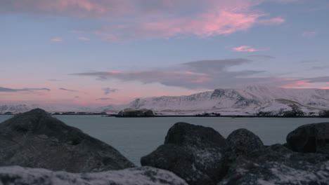 Schneebedeckte-Berge,-Rosa-Wolken-über-Der-Küste-Von-Reykjavik,-Zeitraffer