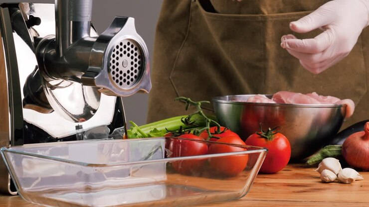 Preparazione del pollo per la cottura con il tritacarne