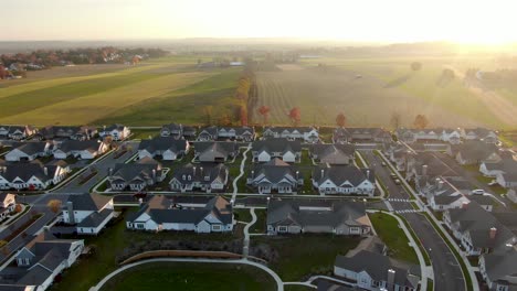 toma aérea de un nuevo desarrollo de viviendas junto a campos agrícolas rurales